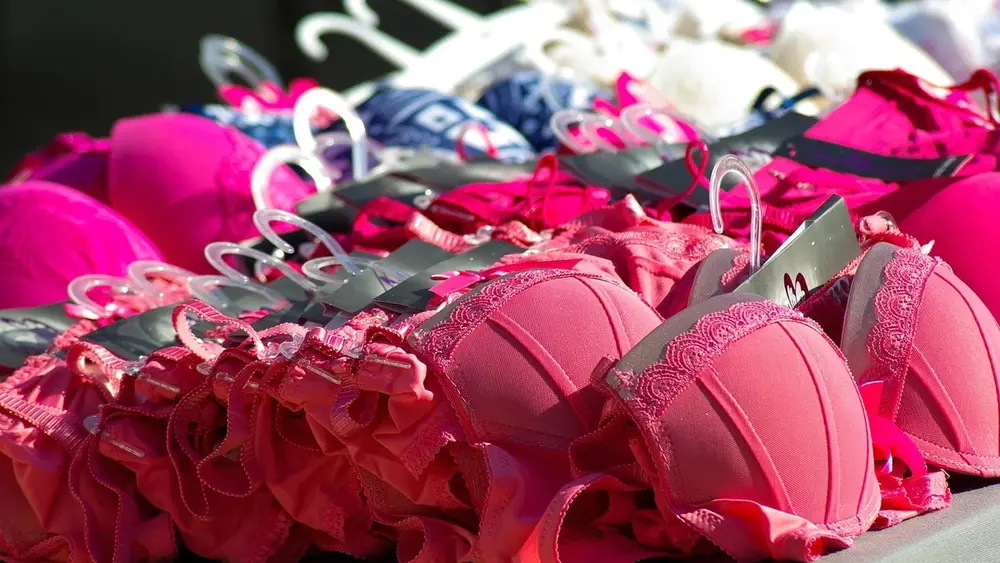 Sutiãs cor-de-rosa em cabides numa arara de loja de lingerie